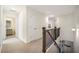 Upstairs hallway with neutral walls and carpet, wooden railing, and access to a full bathroom at 3075 Westpoint Cir, Snellville, GA 30078
