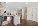 Modern kitchen with island seating and stainless appliances open to the living and dining area at 3075 Westpoint Cir, Snellville, GA 30078