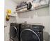Close-up of modern, black, front-load washer and dryer units inside a laundry room with shelving at 3075 Westpoint Cir, Snellville, GA 30078