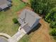 Aerial view showcasing home's setting, roof, driveway, and mature trees at 33 New Kent Ct, Villa Rica, GA 30180