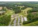 Aerial view of a golf course with a parking lot, clubhouse, and surrounding green landscape at 33 New Kent Ct, Villa Rica, GA 30180