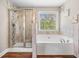 Bathroom featuring a tiled shower, soaking tub, and a large window at 33 New Kent Ct, Villa Rica, GA 30180