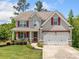 Charming two-story home with a well-manicured lawn, red shutters, and a two-car garage at 33 New Kent Ct, Villa Rica, GA 30180