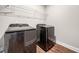 Modern laundry room featuring dark appliances and wooden floors at 33 New Kent Ct, Villa Rica, GA 30180