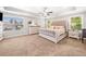 Bright main bedroom featuring tray ceilings, large windows, and neutral decor at 33 New Kent Ct, Villa Rica, GA 30180