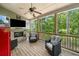 Relaxing covered patio with brick fireplace, ceiling fan, and comfortable wicker furniture at 33 New Kent Ct, Villa Rica, GA 30180