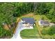 An aerial view of a modern home with a long driveway, a lush lawn and mature trees at 1349 Oak Road, Lilburn, GA 30047