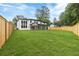 Expansive backyard featuring a modern white home with large windows and a covered patio at 1349 Oak Road, Lilburn, GA 30047
