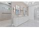 Elegant bathroom features a walk-in shower, dual vanity sinks, statement mirrors, and luxury lighting at 1349 Oak Road, Lilburn, GA 30047