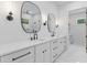Elegant bathroom featuring double vanities, unique mirrors, and sconces, complemented by a glass-enclosed shower at 1349 Oak Road, Lilburn, GA 30047