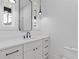 Modern bathroom with a black framed mirror, white cabinets, sleek hardware, and pendant lighting at 1349 Oak Road, Lilburn, GA 30047