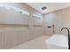 Brightly lit modern bathroom featuring soaking tub and separate tiled shower with dual shower heads at 1349 Oak Road, Lilburn, GA 30047