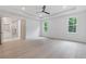 Bright bedroom featuring an ensuite bath, tray ceiling, hardwood floors and modern ceiling fan at 1349 Oak Road, Lilburn, GA 30047