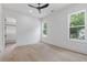 Bright bedroom with light hardwood floors, two windows, ceiling fan, and walk-in closet at 1349 Oak Road, Lilburn, GA 30047