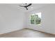 Bright bedroom featuring wood floors, a ceiling fan, and a window with a view of the outdoors at 1349 Oak Road, Lilburn, GA 30047