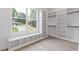 Walk-in closet featuring built in shelving and drawers, and a window seat with storage at 1349 Oak Road, Lilburn, GA 30047
