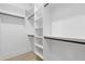 Walk-in closet with white shelves and black rods for ample storage space at 1349 Oak Road, Lilburn, GA 30047