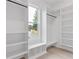 Spacious walk-in closet featuring a window, shelves, benches, and clothing rods at 1349 Oak Road, Lilburn, GA 30047
