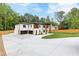 Expansive driveway leading to a modern two-story home with a white brick and wood facade and attached garage at 1349 Oak Road, Lilburn, GA 30047