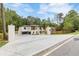 Long driveway leading to a modern home with a combination of wood and white brick, and a black privacy fence at 1349 Oak Road, Lilburn, GA 30047