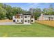 Attractive two-story home with a combination of white brick and wood, set on a large, green lot at 1349 Oak Road, Lilburn, GA 30047
