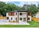 Beautifully designed two-story home with a mix of white brick and wood, complemented by lush green lawn at 1349 Oak Road, Lilburn, GA 30047
