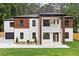 Stunning two-story home featuring a modern design with a combination of white brick and wood accents at 1349 Oak Road, Lilburn, GA 30047