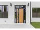 Contemporary front door framed by sleek black accents and modern lighting, set in a white brick facade at 1349 Oak Road, Lilburn, GA 30047