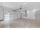 Spacious three car garage featuring a modern door and neutral epoxy flooring at 1349 Oak Road, Lilburn, GA 30047