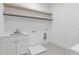 Modern laundry room with white cabinets, sink, countertop, and neutral-toned floors at 1349 Oak Road, Lilburn, GA 30047