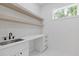 Functional laundry room features floating shelves, ample counter space, a sink, and convenient storage solutions at 1349 Oak Road, Lilburn, GA 30047