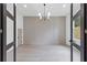 Elegant living room with paneled accent wall, hardwood floors and modern chandelier at 1349 Oak Road, Lilburn, GA 30047