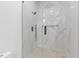 Elegant walk-in shower with glass doors, marble-look tiles, and a black showerhead at 1349 Oak Road, Lilburn, GA 30047