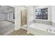 A bathroom with a walk-in shower, bathtub, and outside views at 1462 Stephens View Dr, Loganville, GA 30052