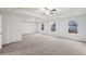 A large bedroom with tray ceilings, ceiling fan, three windows and neutral-colored carpet at 1462 Stephens View Dr, Loganville, GA 30052