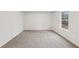 An empty bedroom features plush carpeting, white walls, and a bright window at 1462 Stephens View Dr, Loganville, GA 30052
