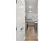 Hallway featuring wood laminate floors, a closet, and view of a stylish kitchen with gray cabinets at 1462 Stephens View Dr, Loganville, GA 30052