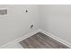 An unfinished laundry room features gray wood flooring and white walls at 1462 Stephens View Dr, Loganville, GA 30052