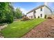 Expansive backyard with lush green grass and a wooden deck, surrounded by mature trees at 523 Huntgate Rd, Woodstock, GA 30189