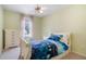Cozy bedroom features a charming bed with blue covers, dresser, and natural light from the window at 523 Huntgate Rd, Woodstock, GA 30189