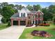 Charming brick two-story home with a two-car garage and a beautifully landscaped front yard at 523 Huntgate Rd, Woodstock, GA 30189