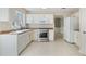Clean, tiled kitchen features stainless appliances, white cabinets, and view to another room at 523 Huntgate Rd, Woodstock, GA 30189