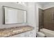 Well-lit bathroom featuring granite countertops, modern fixtures, and a stylish mirror and shower at 5981 Brundage Ln, Norcross, GA 30071