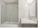 Bathroom featuring glass-enclosed tub and vanity with granite countertop and fixtures at 5981 Brundage Ln, Norcross, GA 30071