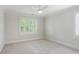 A carpeted bedroom with a ceiling fan and shuttered windows at 5981 Brundage Ln, Norcross, GA 30071