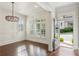 Elegant entryway featuring hardwood floors, white trim, an ornate chandelier, and plantation shutters at 5981 Brundage Ln, Norcross, GA 30071