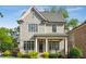 Charming two-story home featuring a covered front porch, classic gray siding, and beautifully manicured landscaping at 5981 Brundage Ln, Norcross, GA 30071