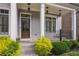 Inviting front porch with decorative columns, a dark wood front door, and colorful landscaping at 5981 Brundage Ln, Norcross, GA 30071