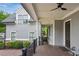 Inviting covered porch with wood decking, columns, and a brick accent wall, offering a perfect blend of comfort and style at 5981 Brundage Ln, Norcross, GA 30071