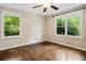 Inviting bedroom featuring hardwood floors, a ceiling fan, and abundant natural light from the large windows at 1053 Crane Ne Rd, Atlanta, GA 30324